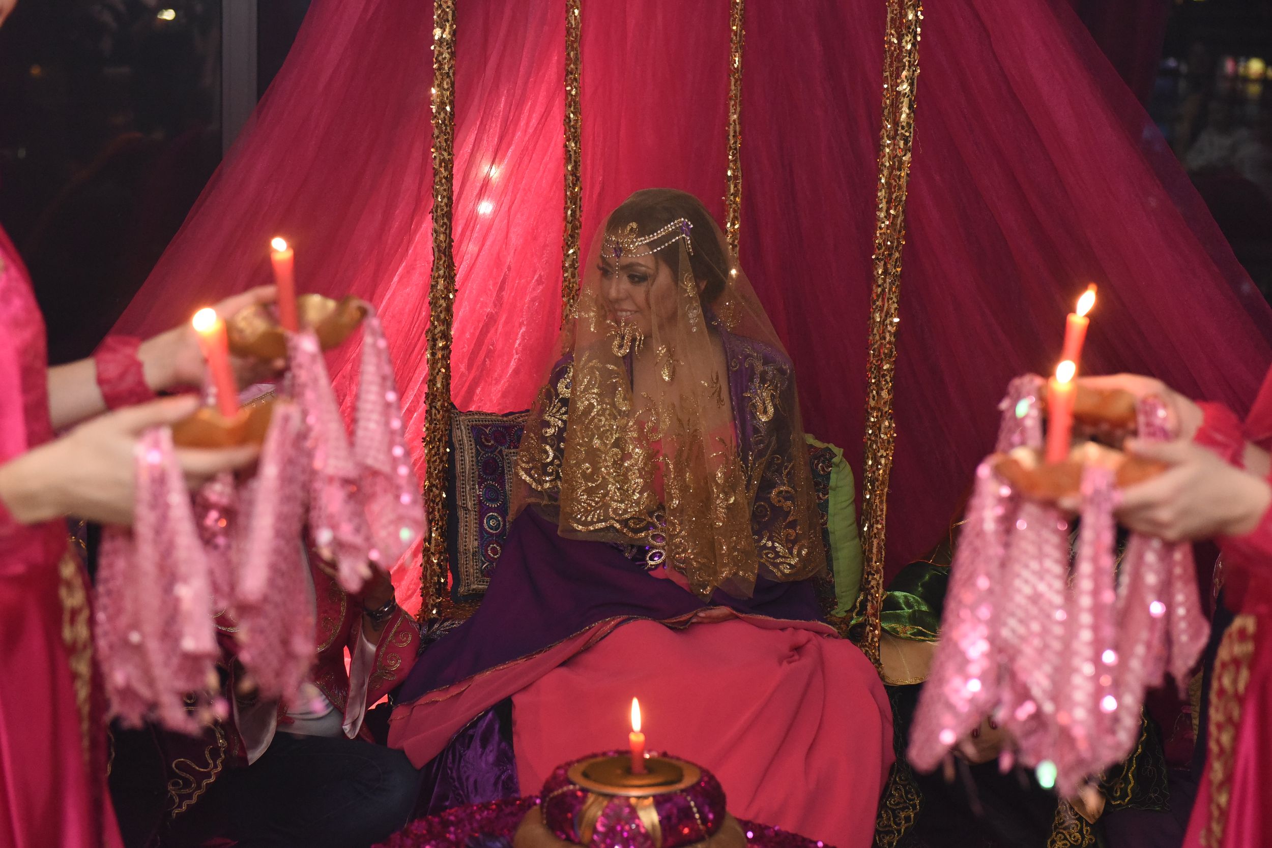 Pink and gold decorative canopy tents with hanging lanterns create a magical outdoor party atmosphere.