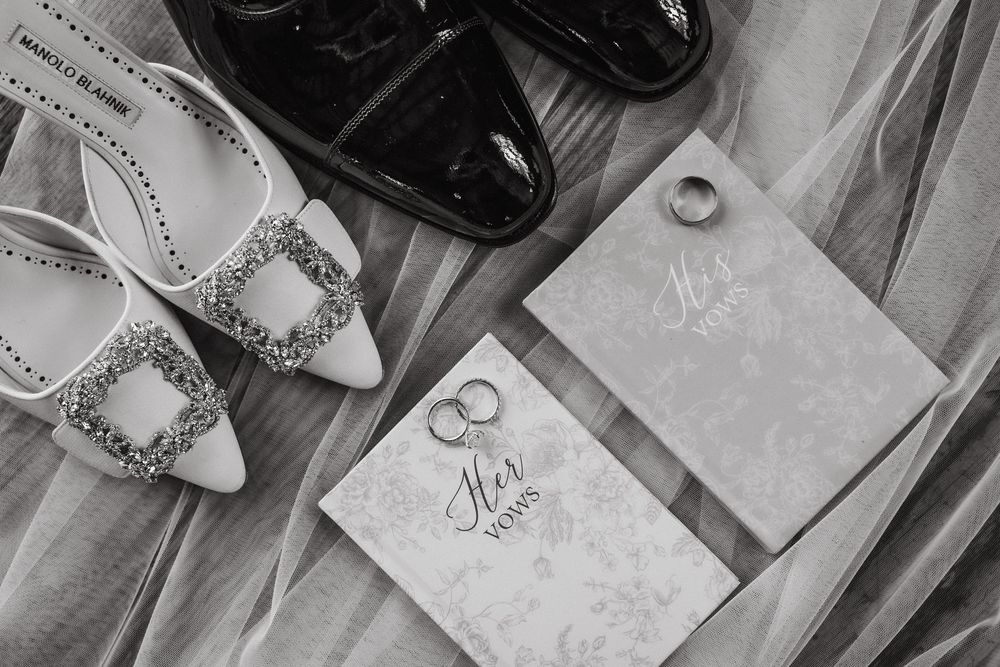 Wedding details including invitation cards, rings, and other accessories laid out on a wooden surface.