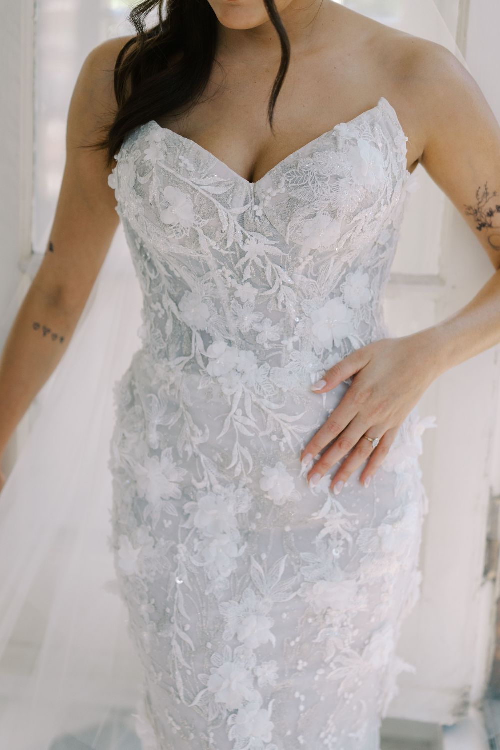 Detailed lace applique and beading on a white strapless wedding gown bodice.