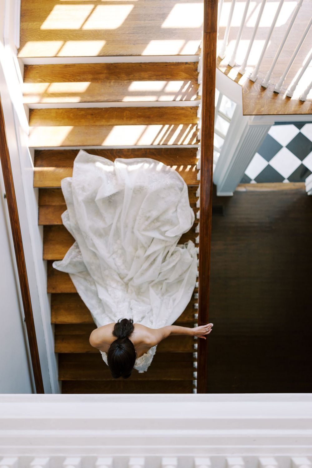 Wedding dress fabric billowing dramatically in natural light through skylight windows.