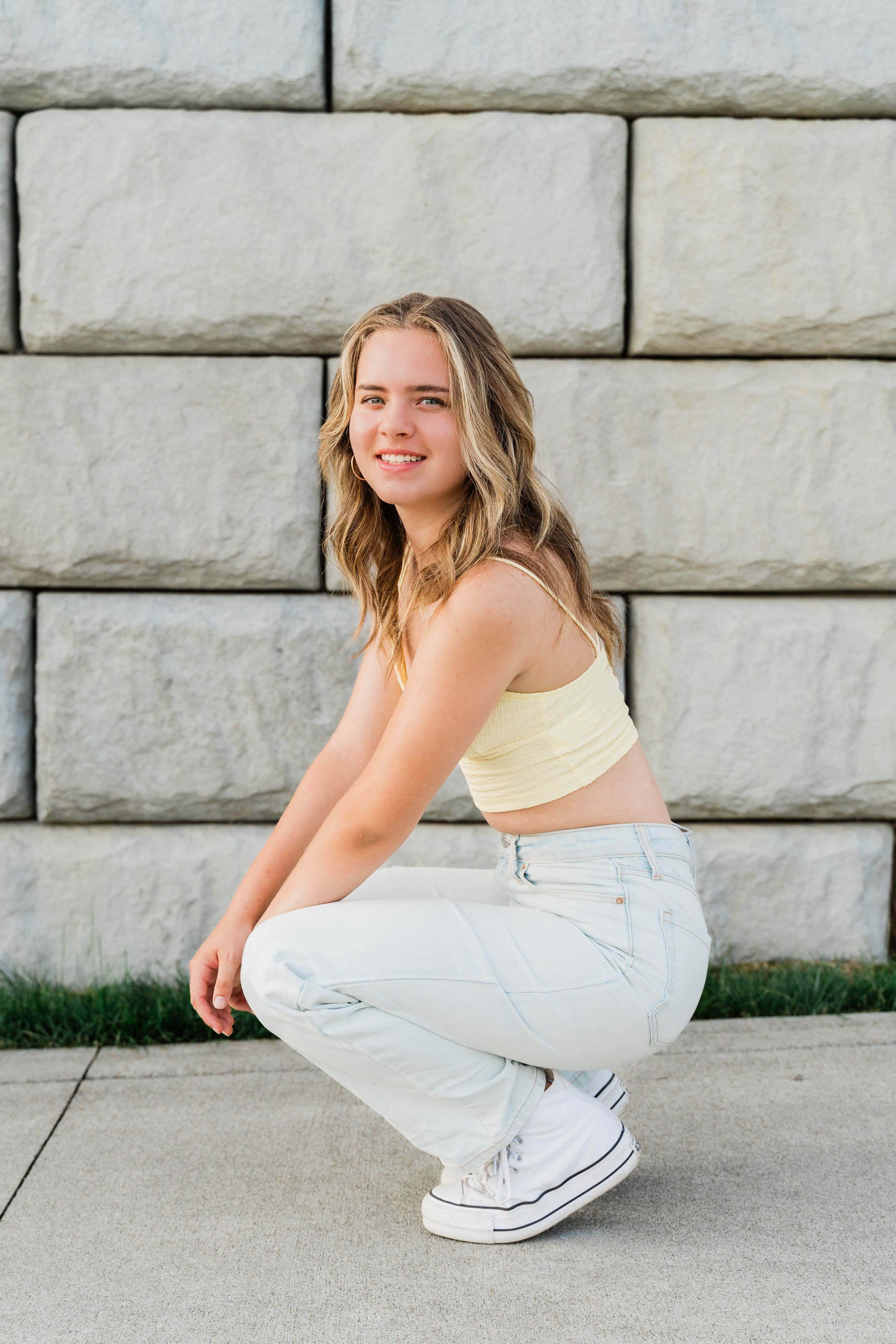 A person in a white outfit sits on a concrete surface in a series of connected poses.