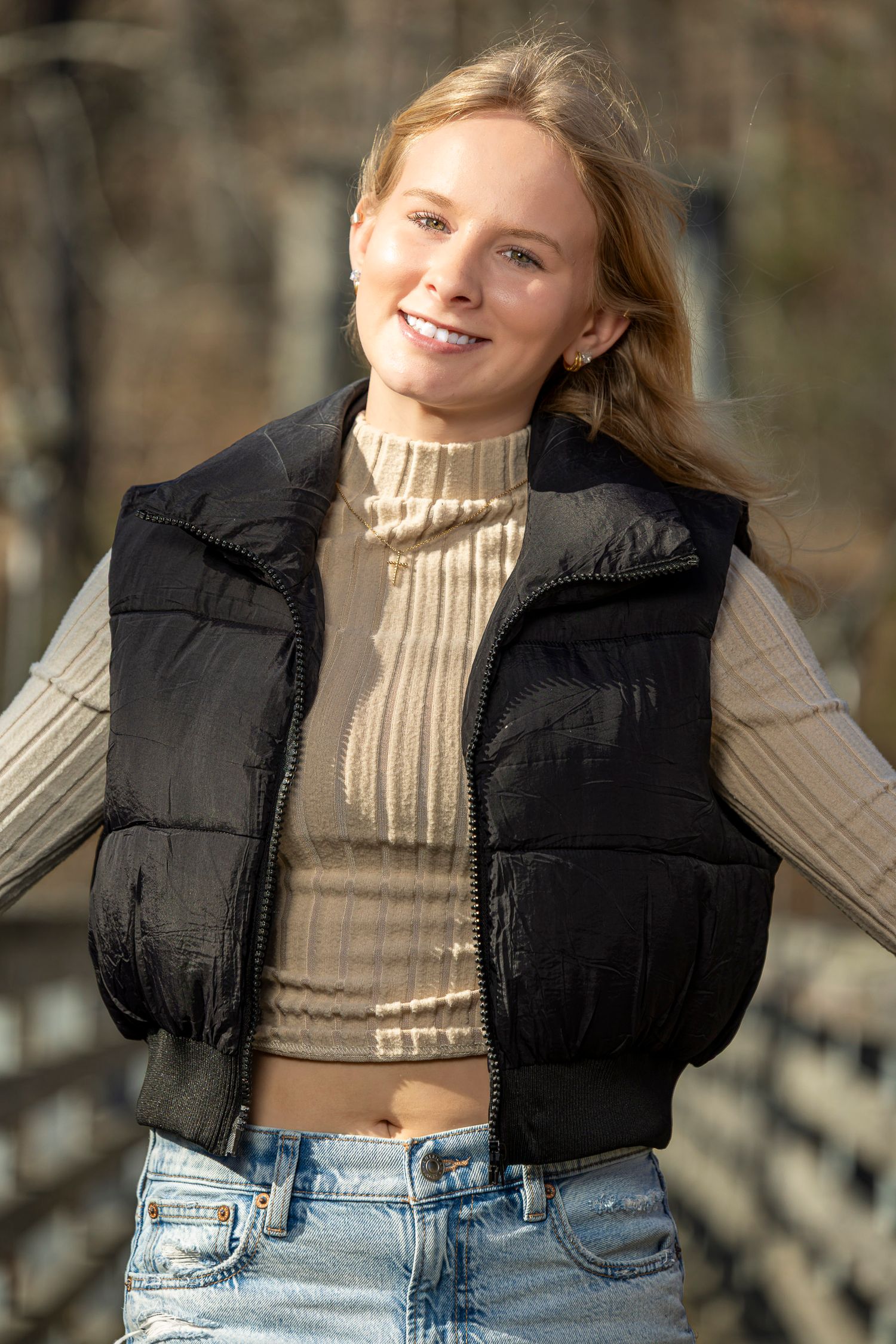 A series of fashion photos showing someone posing in a cropped turtleneck sweater, black vest, and jeans outdoors.