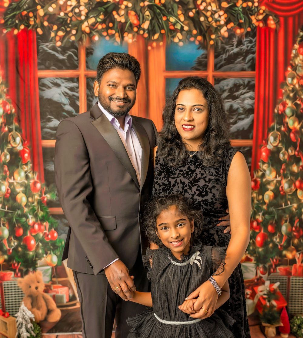 A festive Christmas photoshoot setup with red window frames, twinkling lights, and greenery decorations.