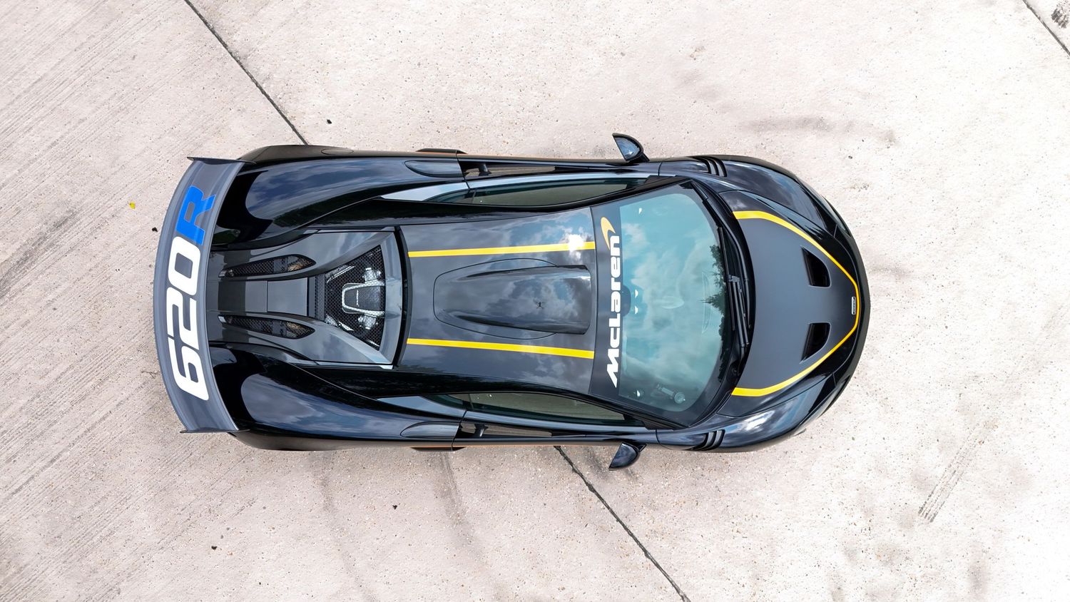 Sleek blue sports car photographed in motion on a racetrack.