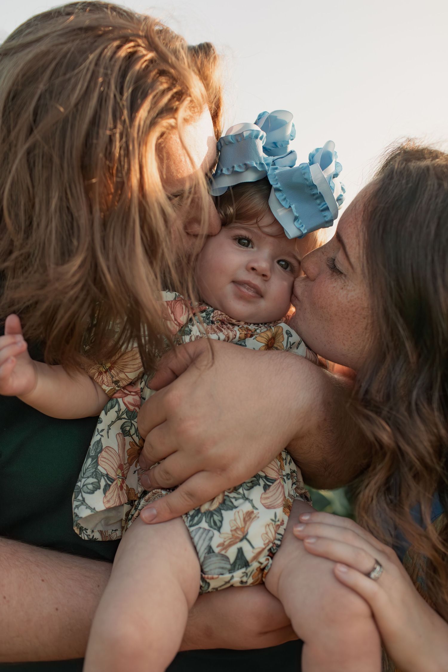 A couple in green and plaid clothing share tender moments while holding a sleeping baby in a series of connected photos.
