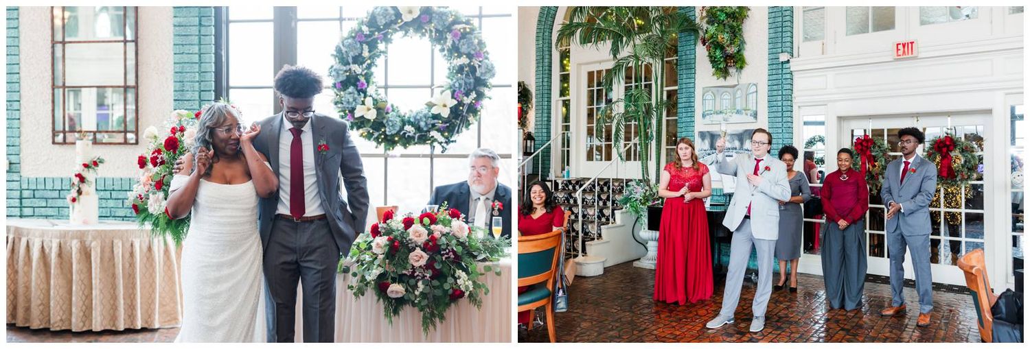Wedding party members celebrate with guests in a festive indoor venue decorated with a wreath and floral arrangements.