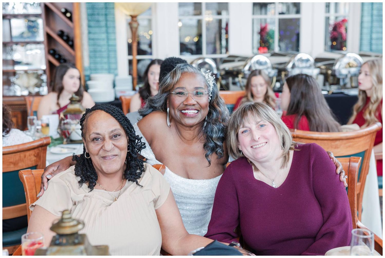 A group of people smiling and laughing together at a restaurant gathering.