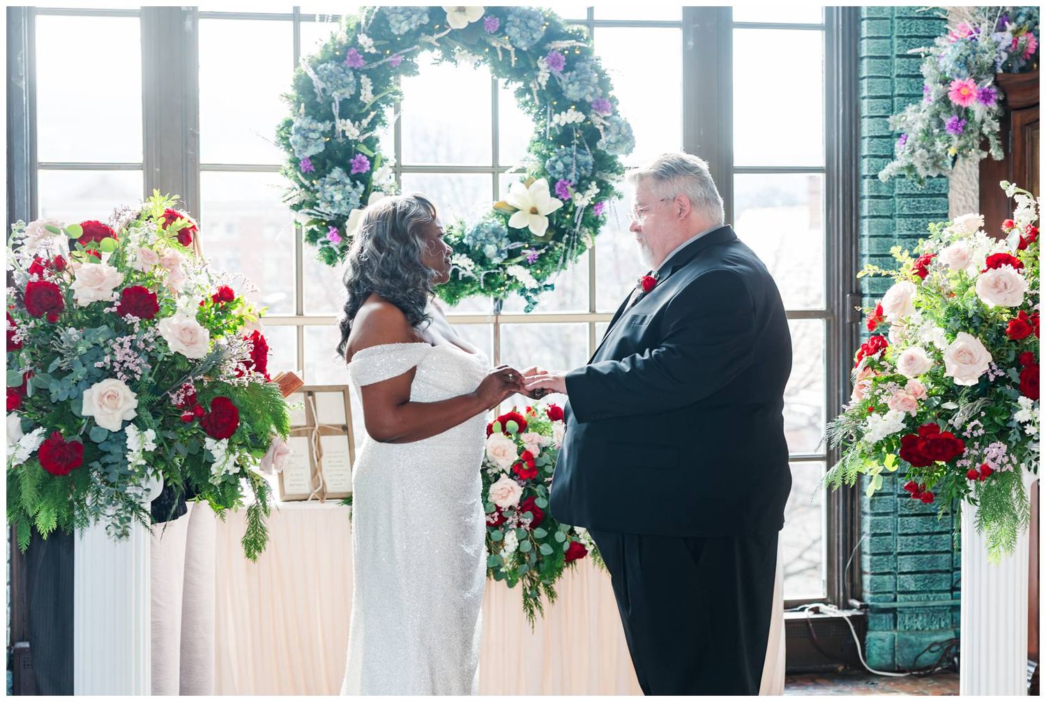 Wedding ceremony panorama showing elegant floral arrangements and guests gathered in a light-filled venue.