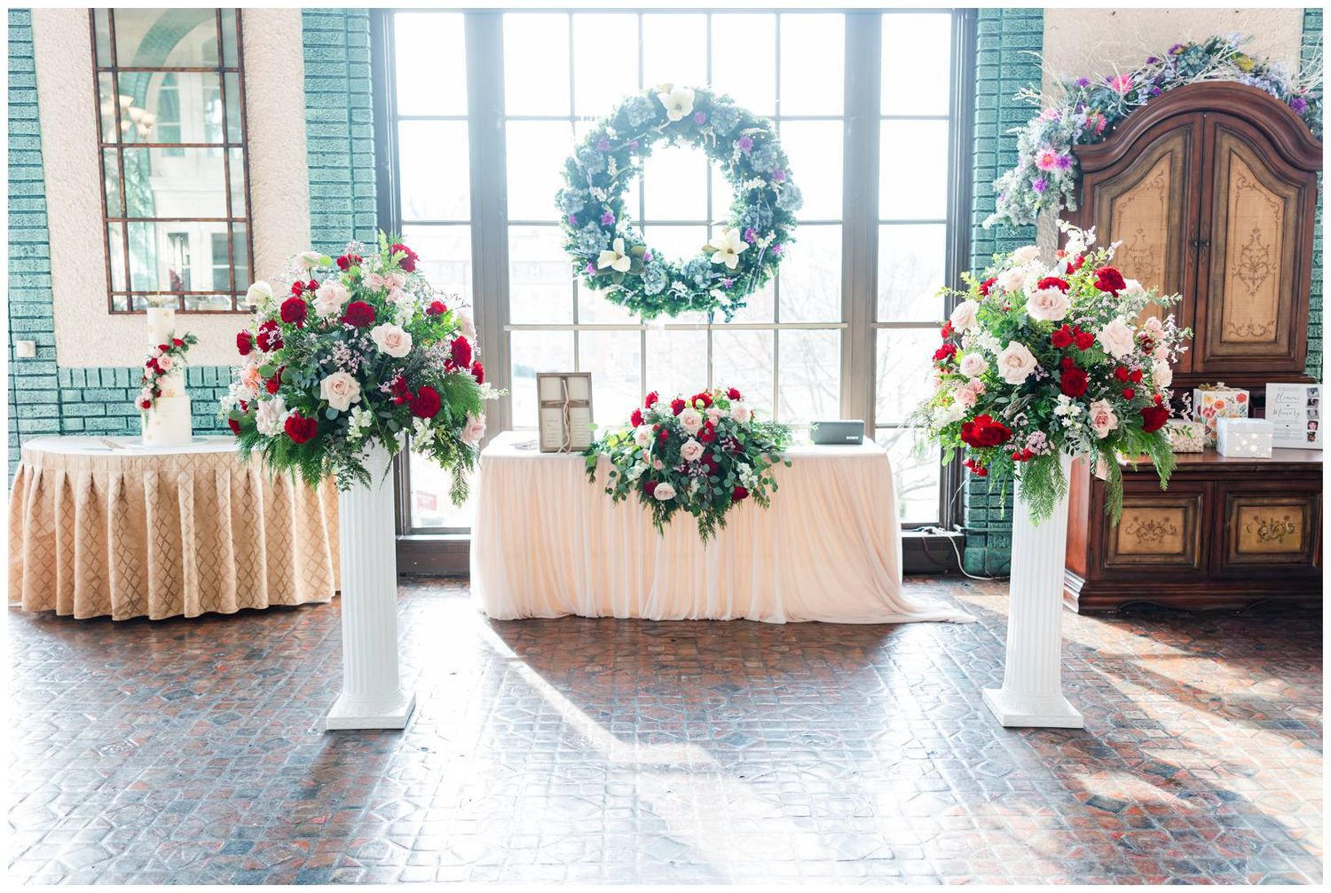 A series of elegant front door entryways decorated with seasonal wreaths and floral arrangements along a covered porch.