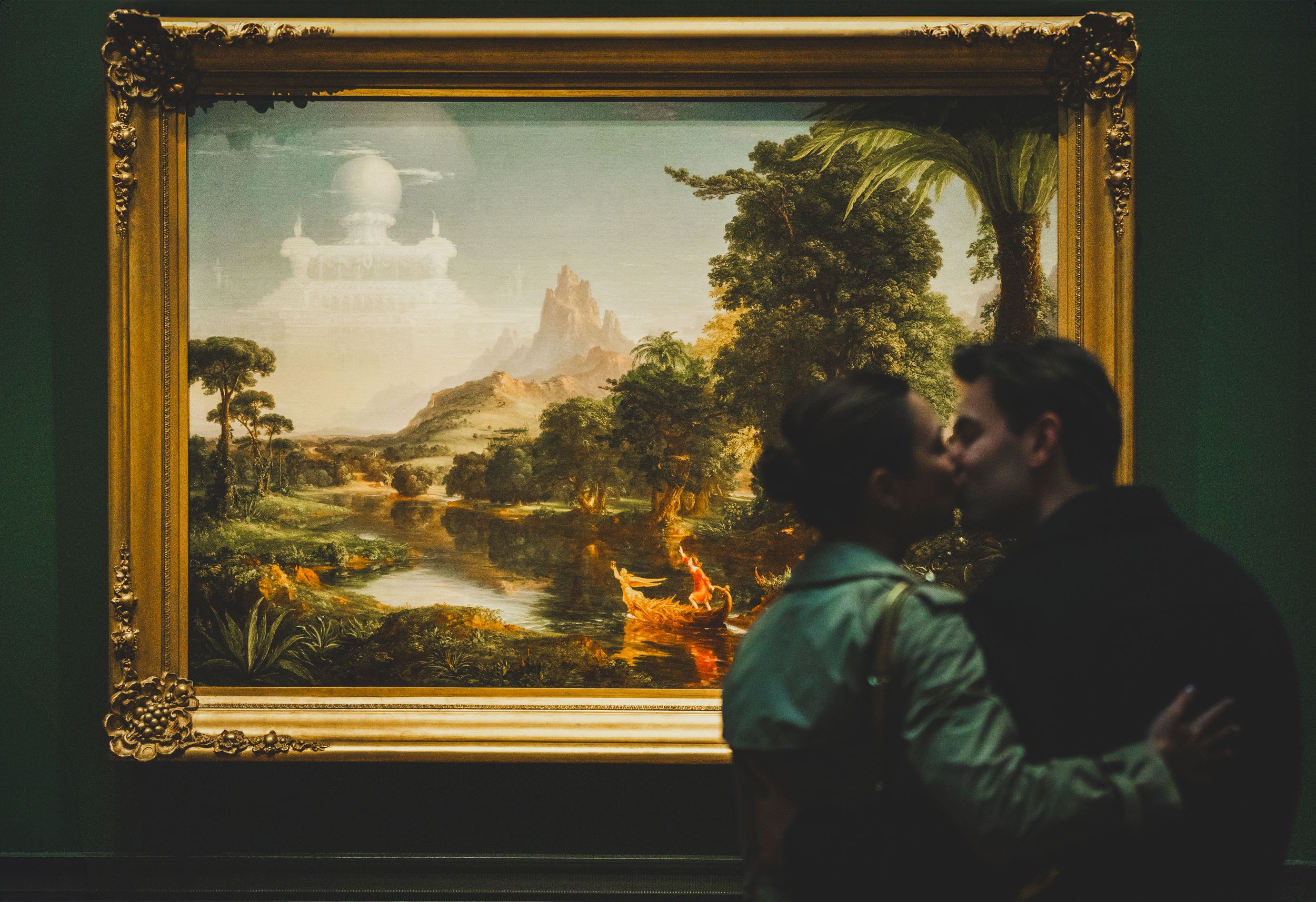 A newly engaged couple kissing in front of portrait at the National Gallery Of Art, a dc winter proposal location