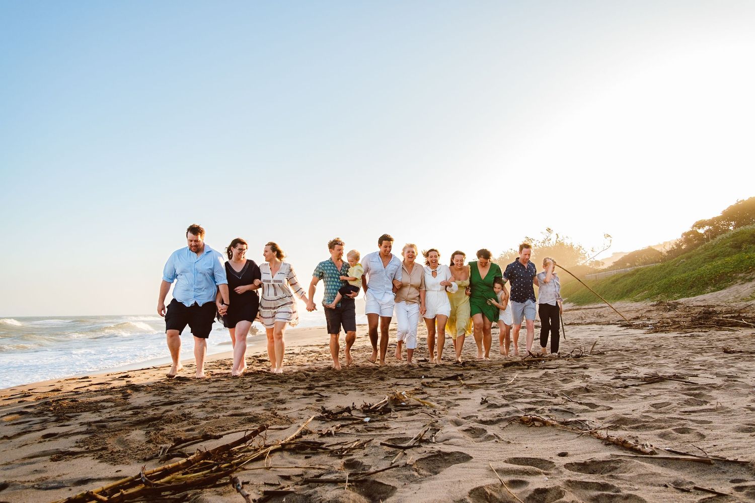 Large family holding hands together outdoors during a natural family photography session