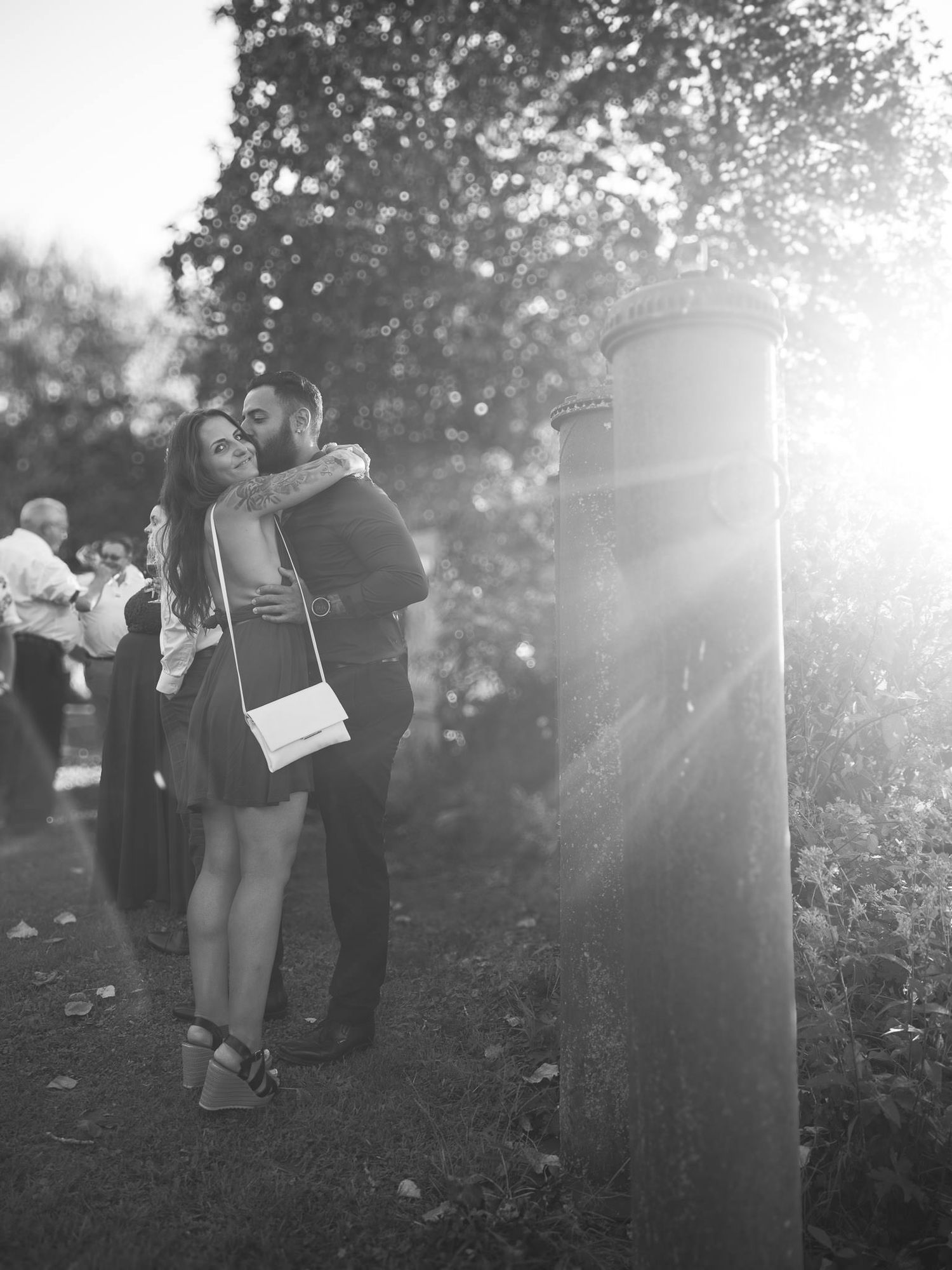 Dreamy outdoor wedding scene with sunlight filtering through trees.