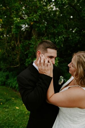 A candid wedding moment showing an emotional embrace in a garden setting.