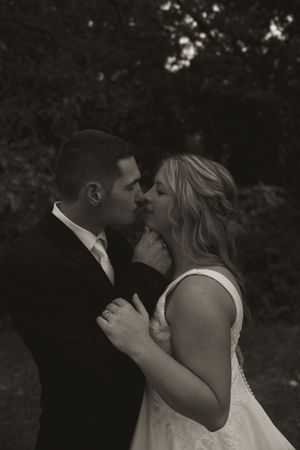 A black and white wedding portrait capturing an intimate moment between newlyweds.