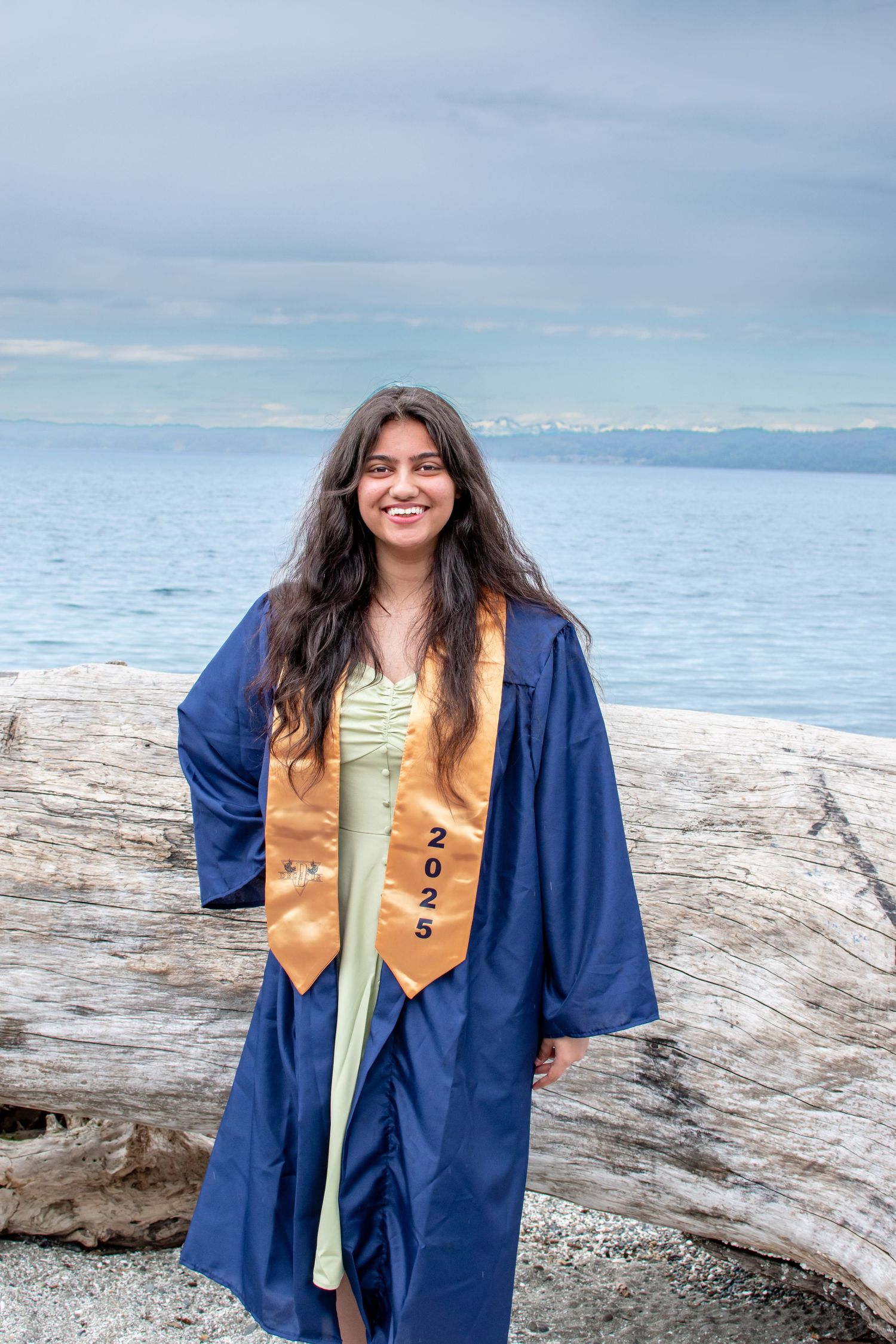 Senior graduation photo by the water in Federal Way – cap and gown session with coastal backdrop.