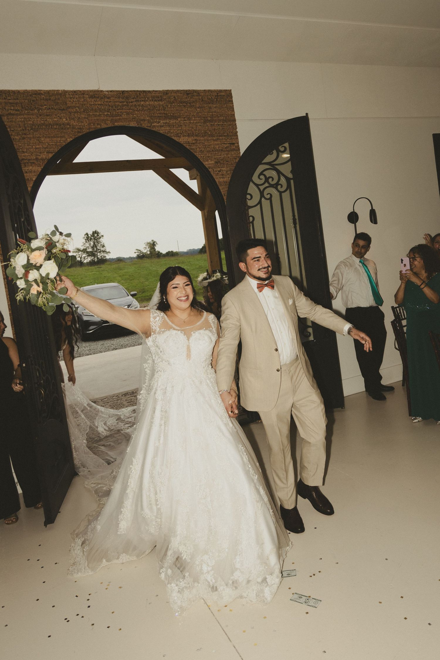 Newlyweds dance and celebrate with guests on the dance floor at their wedding reception venue.