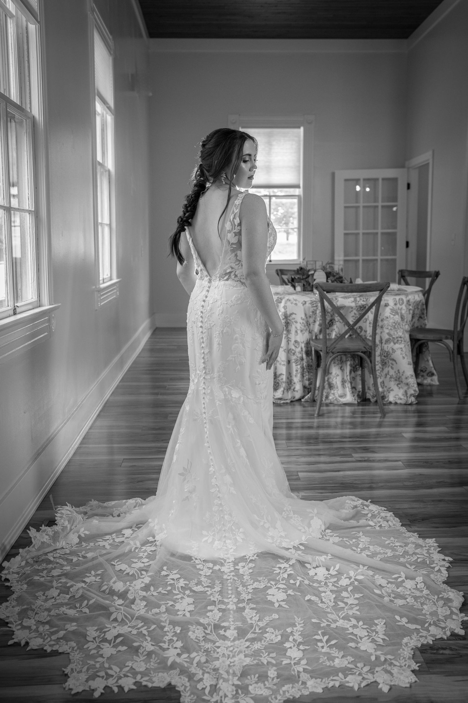 A series of black and white photos showing the elegant train of a white lace wedding dress flowing across a hardwood floor.