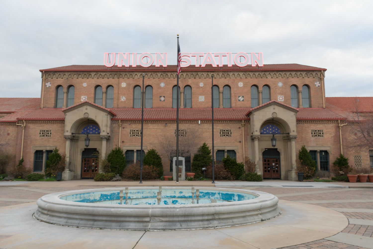Historic Spanish-style building with twin arched entrances and a circular fountain in front at Union Station.