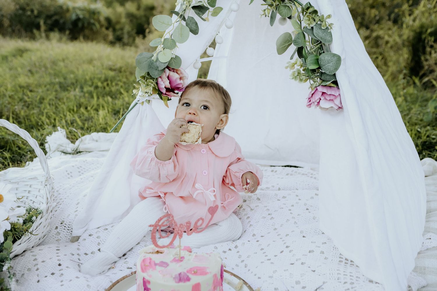 Little girl eating cake during her outdoor cake smash session