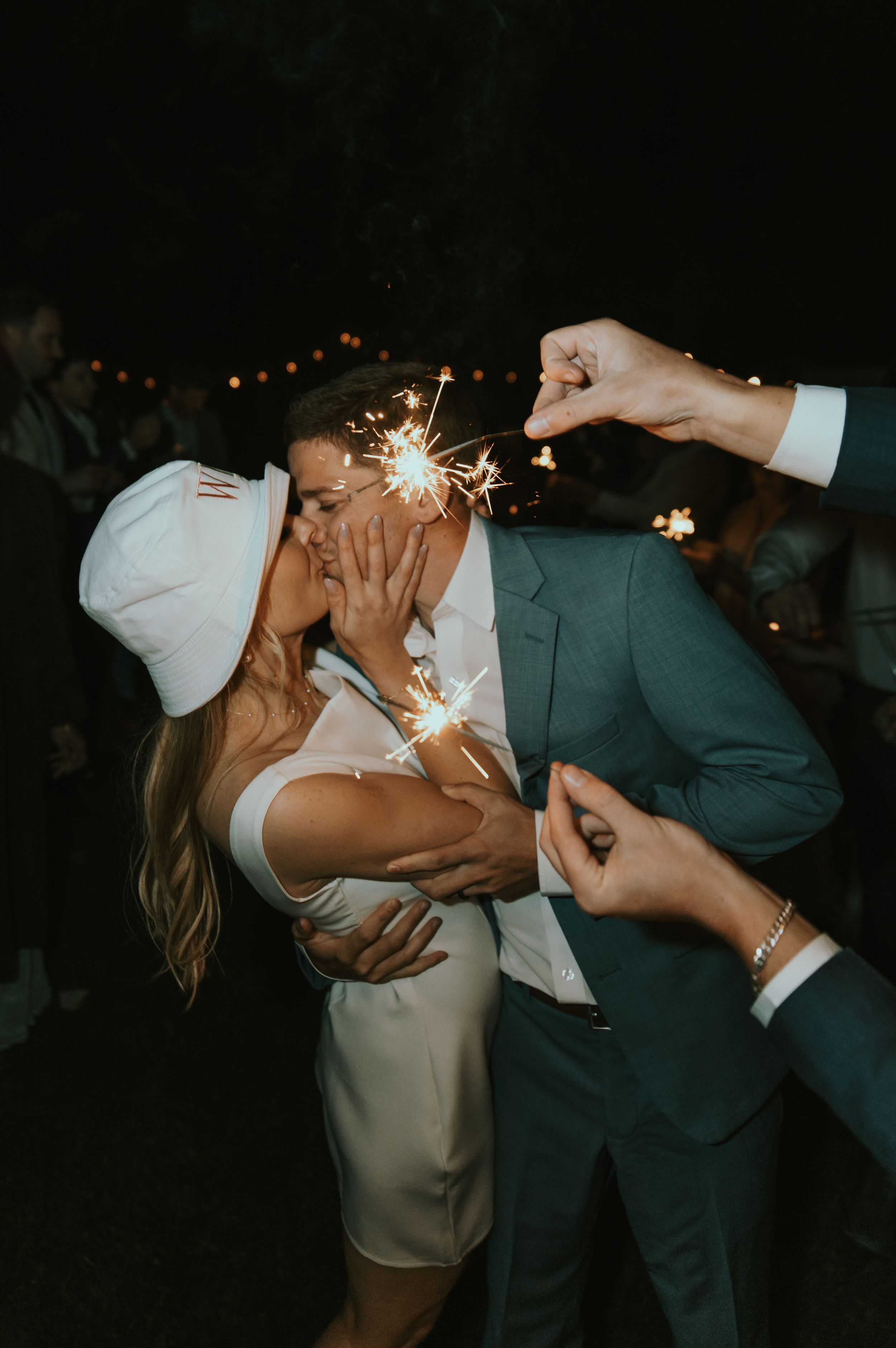 Wedding couple sharing a romantic dance with sparklers at night during their celebration.