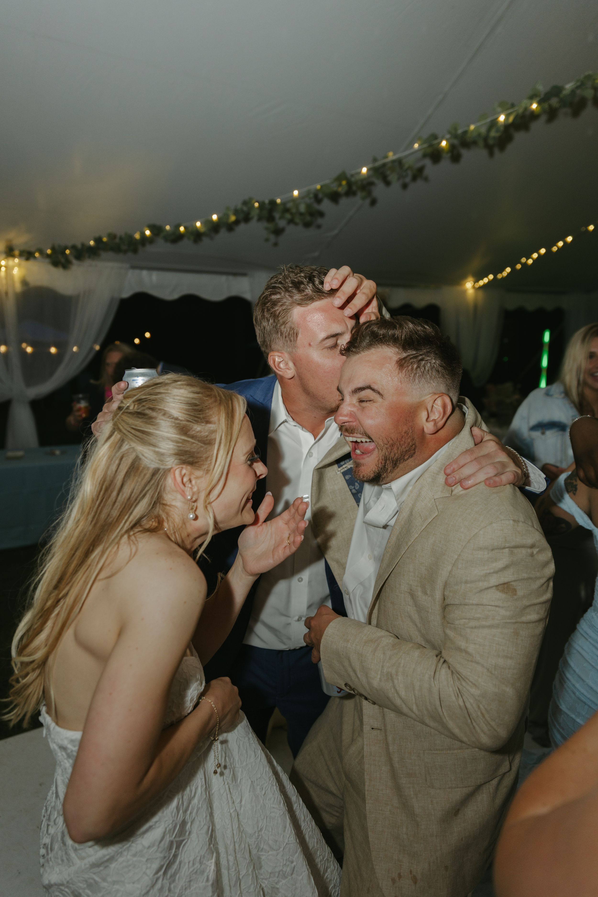 Lively dancing and celebrations at a wedding reception with guests in formal attire.