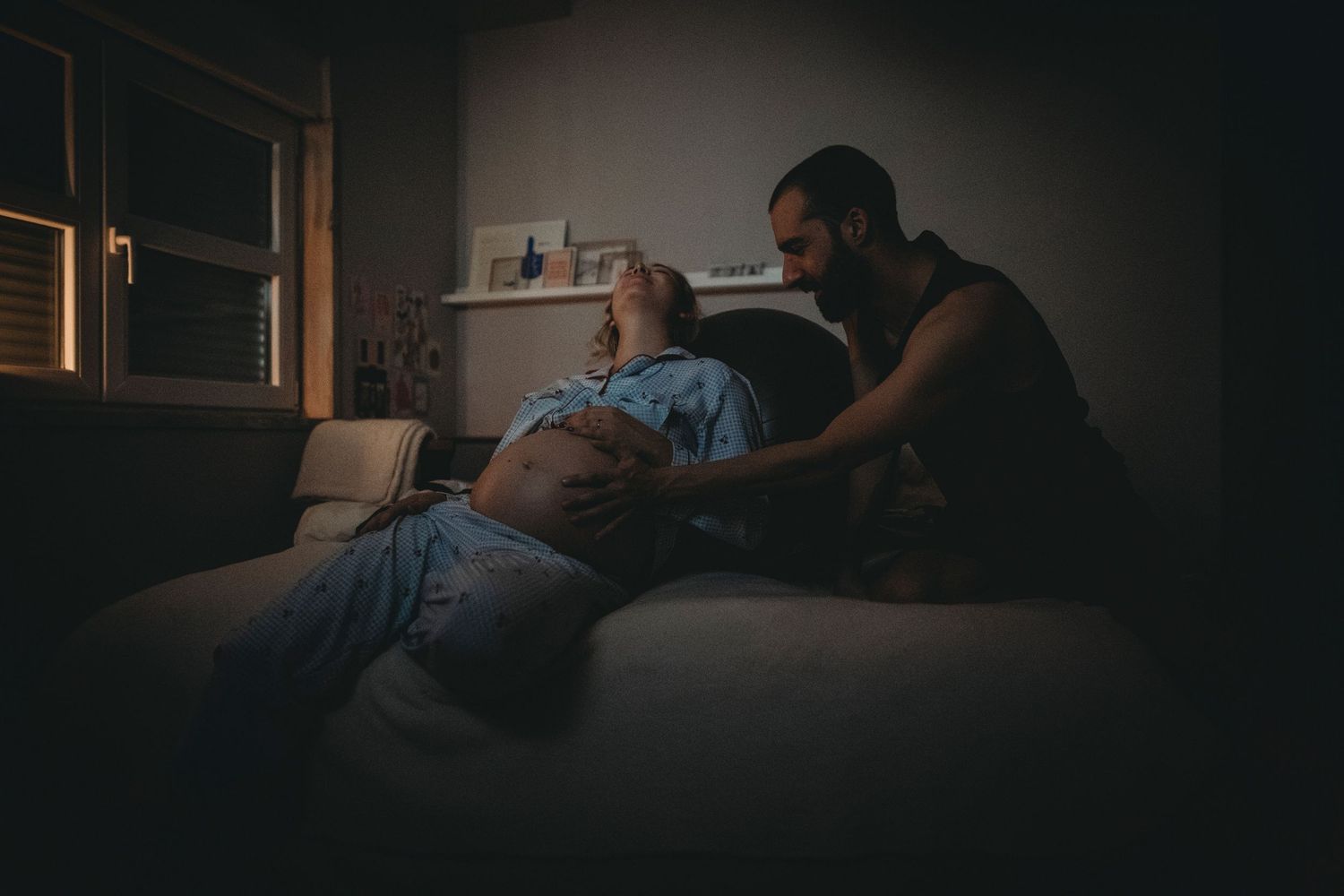 mulher gravida recebe carinho na barriga durante contração em Parto domiciliar em Lisboa