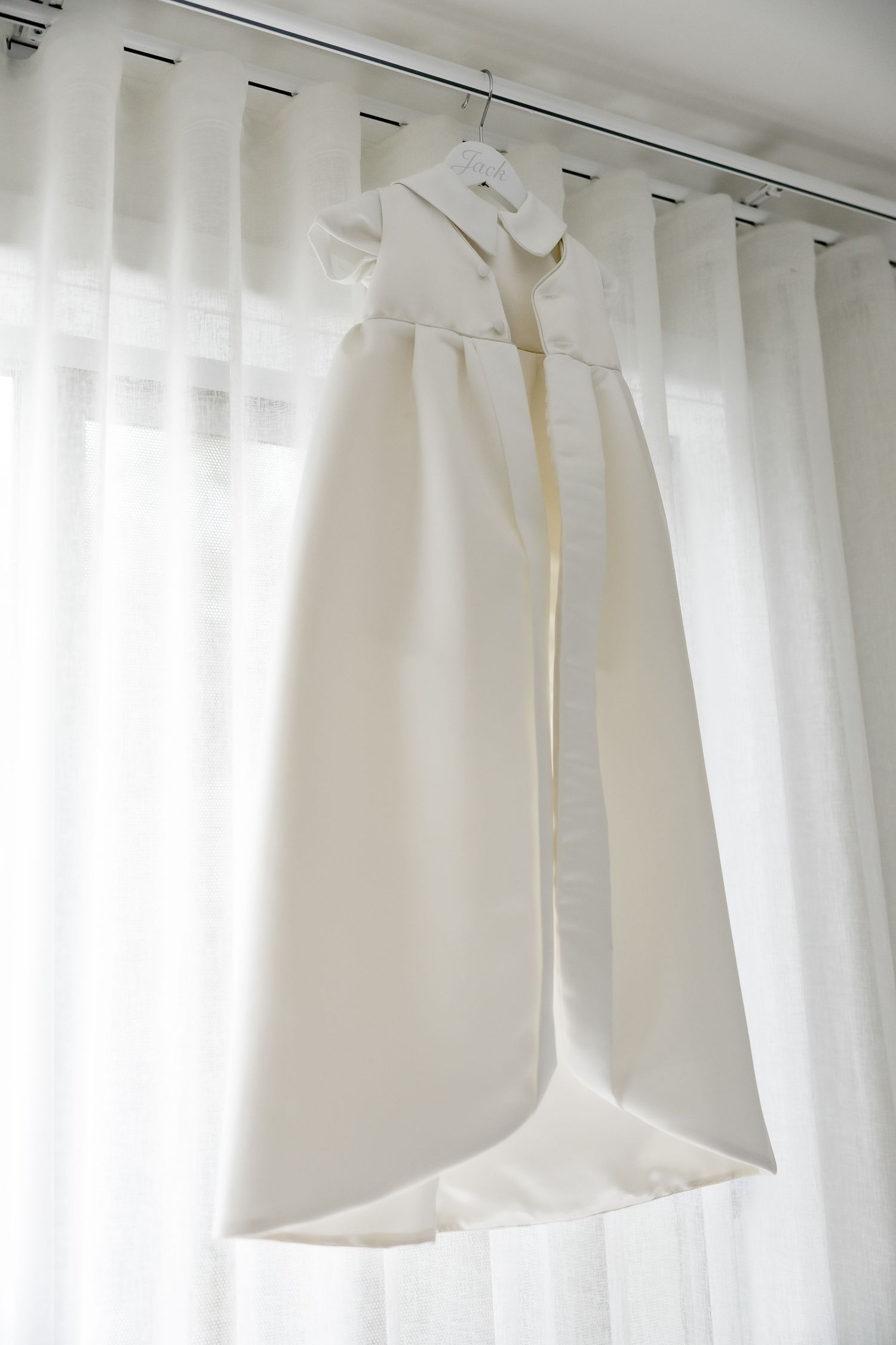 White sheer curtains hanging on curtain rod with natural light filtering through creating a soft, airy atmosphere.