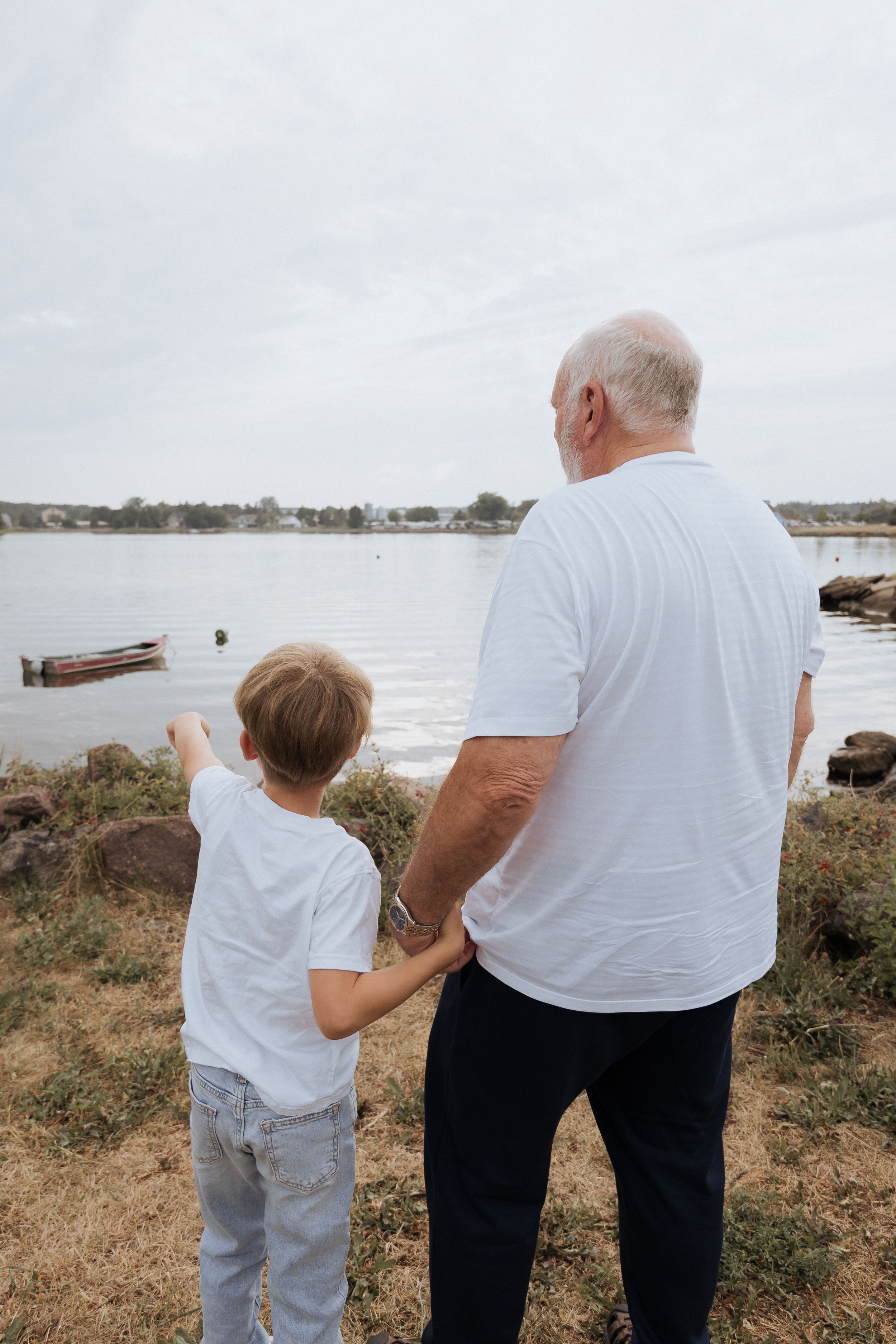grandpa and grandson candid moment family photographer Shediac New Brunswick extended family portraits fishing at Shediac wharf marina