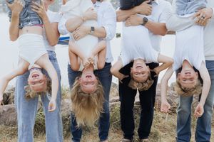 Cousins dangling upside down during extended family photoshoot in Shediac New Brunswick, Moncton family photographer, family portraits