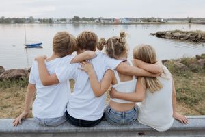 cousins hugging by the water in fun family photography portrait session Shediac New Brunswick photographer family session extended family
