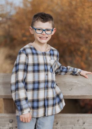 Child poses in front of a stream in October in Dieppe New Brunswick, Moncton family photography packages near me. outdoor lifestyle photos