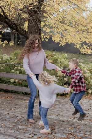 mom and children play ring around the rosie under a tree, fall family photography in Moncton New Brunswick portrait photographer lifestyle