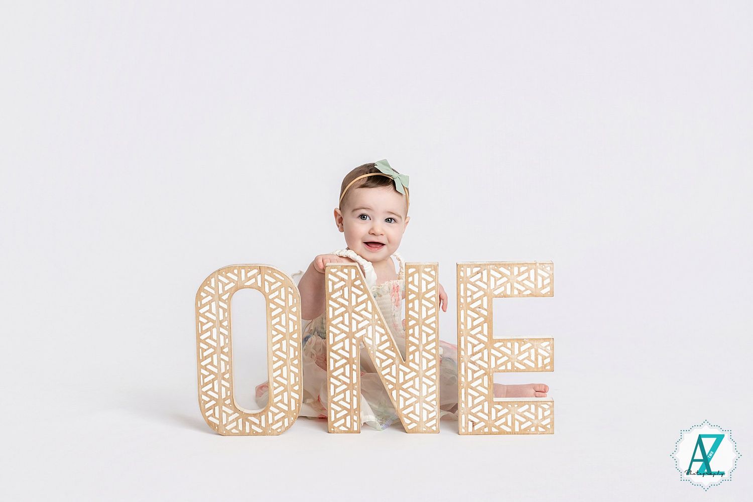 Decorative light-up letter blocks spelling ONE against white backdrop for first birthday photo shoot.
