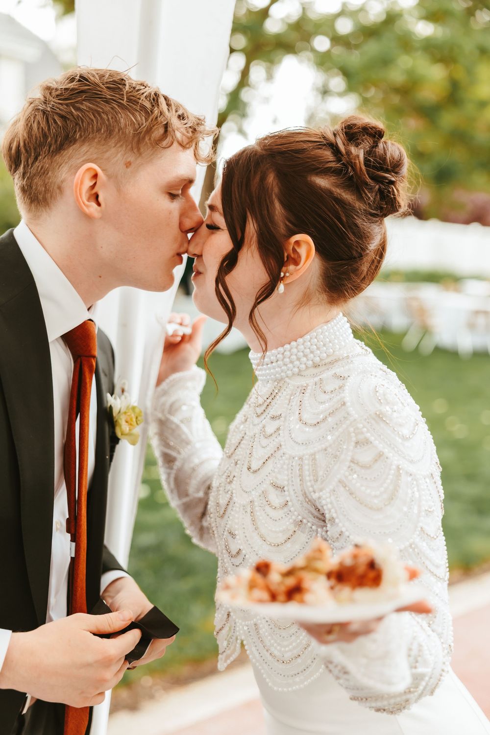 Intimate moment between newlyweds as they share dessert during their wedding celebration.
