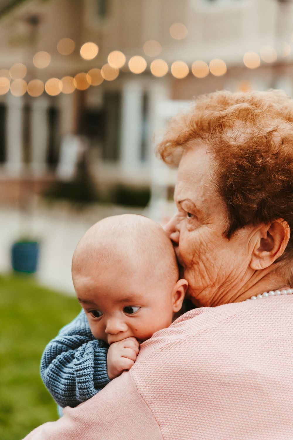 A tender moment shared between an elderly person and baby against a soft bokeh background.