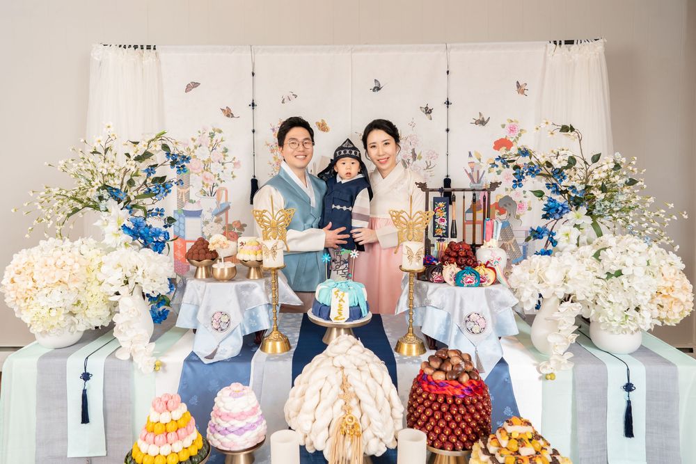 Colorful first birthday party setup with elaborate decorations and dessert table.