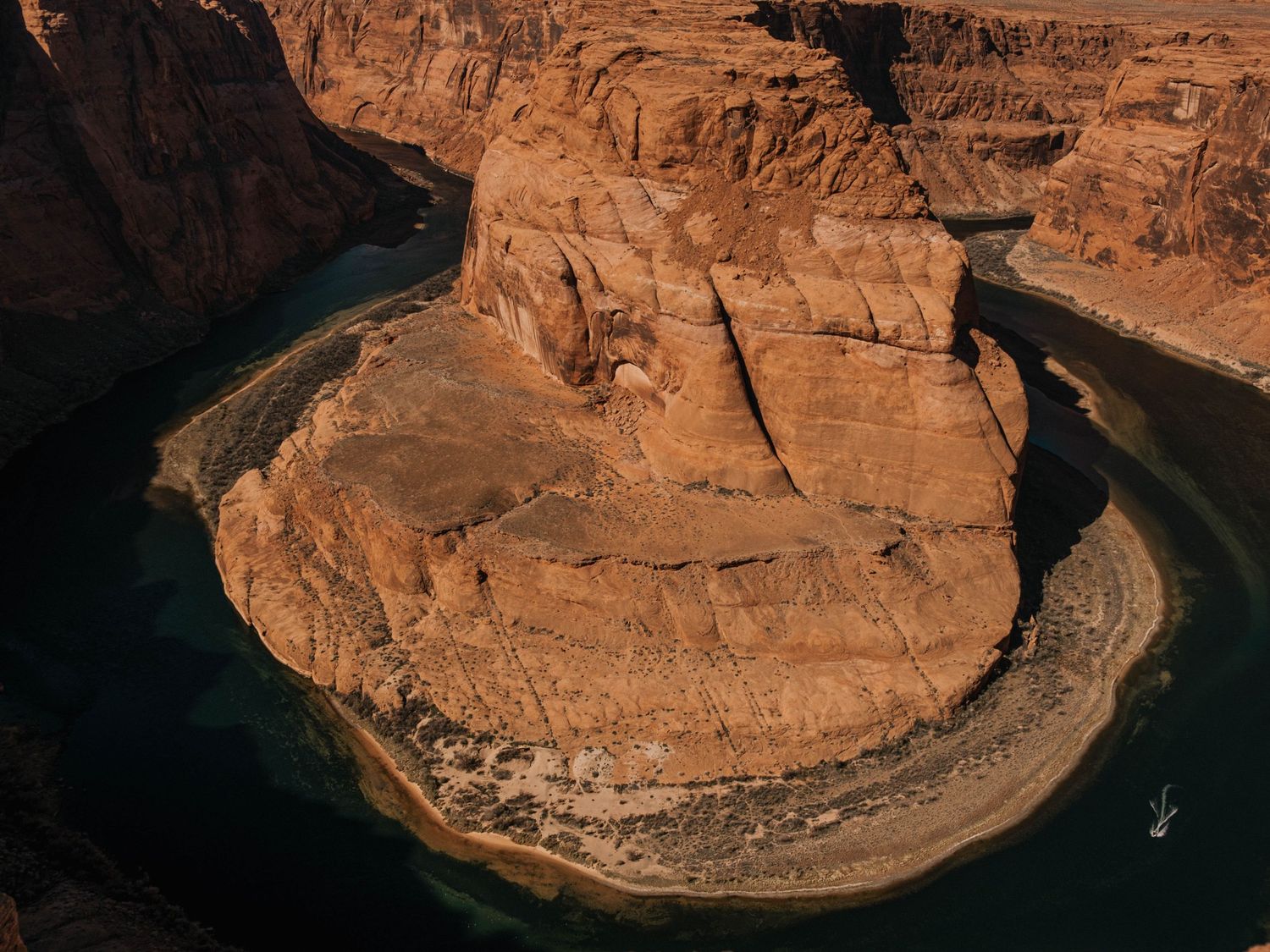 Aerial view of Horseshoe Bend showing the Colorado River curving around red rock formations.