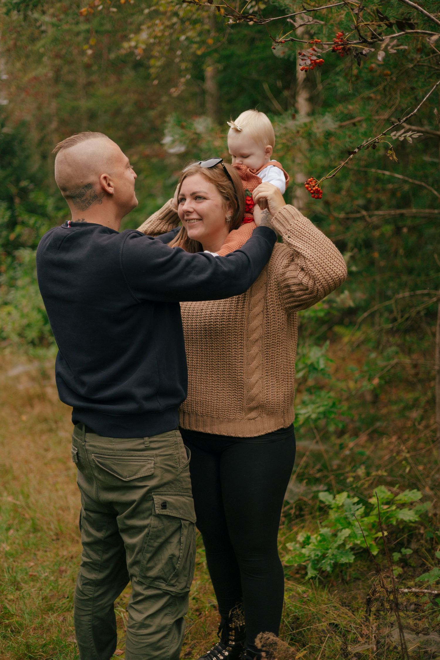 Joyful family moment in autumn woods with cozy sweaters.