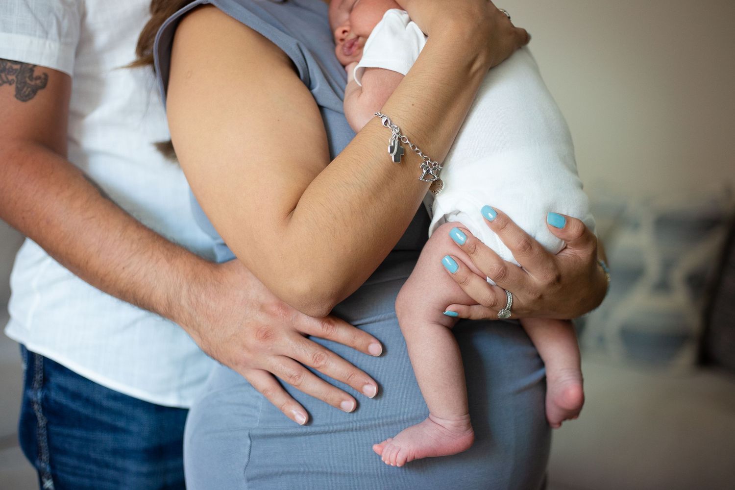 Close-up of hands holding a newborn baby's feet with gentle care and affection.