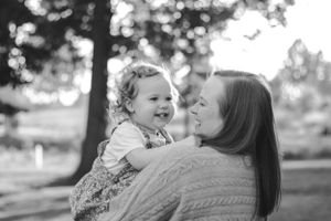 Black and white candid moment of joyful interaction in an outdoor setting.