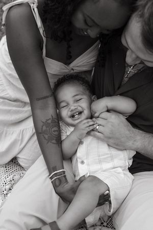 A tender black and white family moment showing affection and laughter.