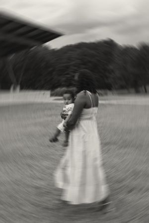 A black and white motion-blurred sequence showing a spinning figure in a white dress creating a circular pattern.