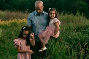 Family shares joyful moments together in a wildflower meadow.