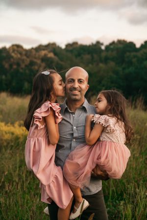 Heartwarming family moment captured in a golden field at sunset.