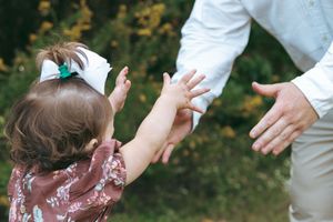 A playful sequence showing joyful interactions between family members in a sunlit outdoor setting.