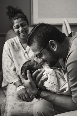 A touching black and white photo series capturing tender moments between family members with a newborn.