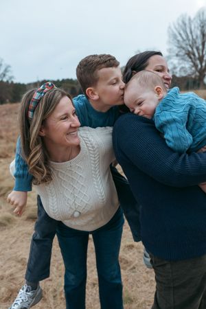 A sequence of playful outdoor family moments showing affectionate interactions in a natural setting.