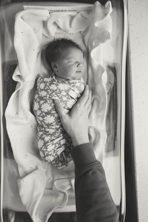 A series of black and white photographs showing a baby being examined in what appears to be a medical setting.