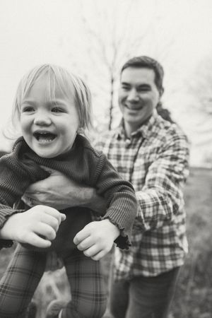 Black and white photo series showing playful moments between parent and child in plaid shirt outdoors.