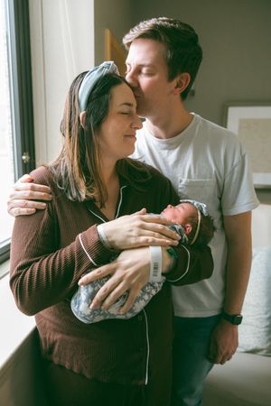 A couple shares tender moments together in a series of intimate indoor photos with natural lighting.